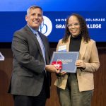 HDFS Ph.D. Student Alexis Ambroise standing with her award with Dean Lou Rossi.